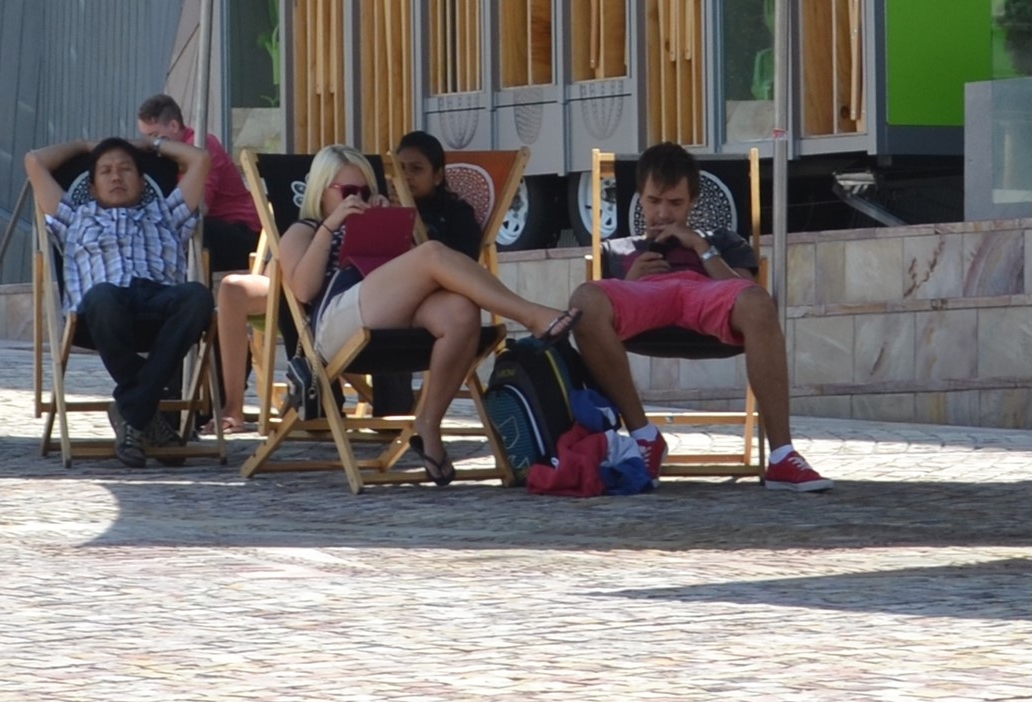 Tablet user sitting in Federation Square, Melbourne Tablet user sitting in the complimentary beach chairs at Federation Square
